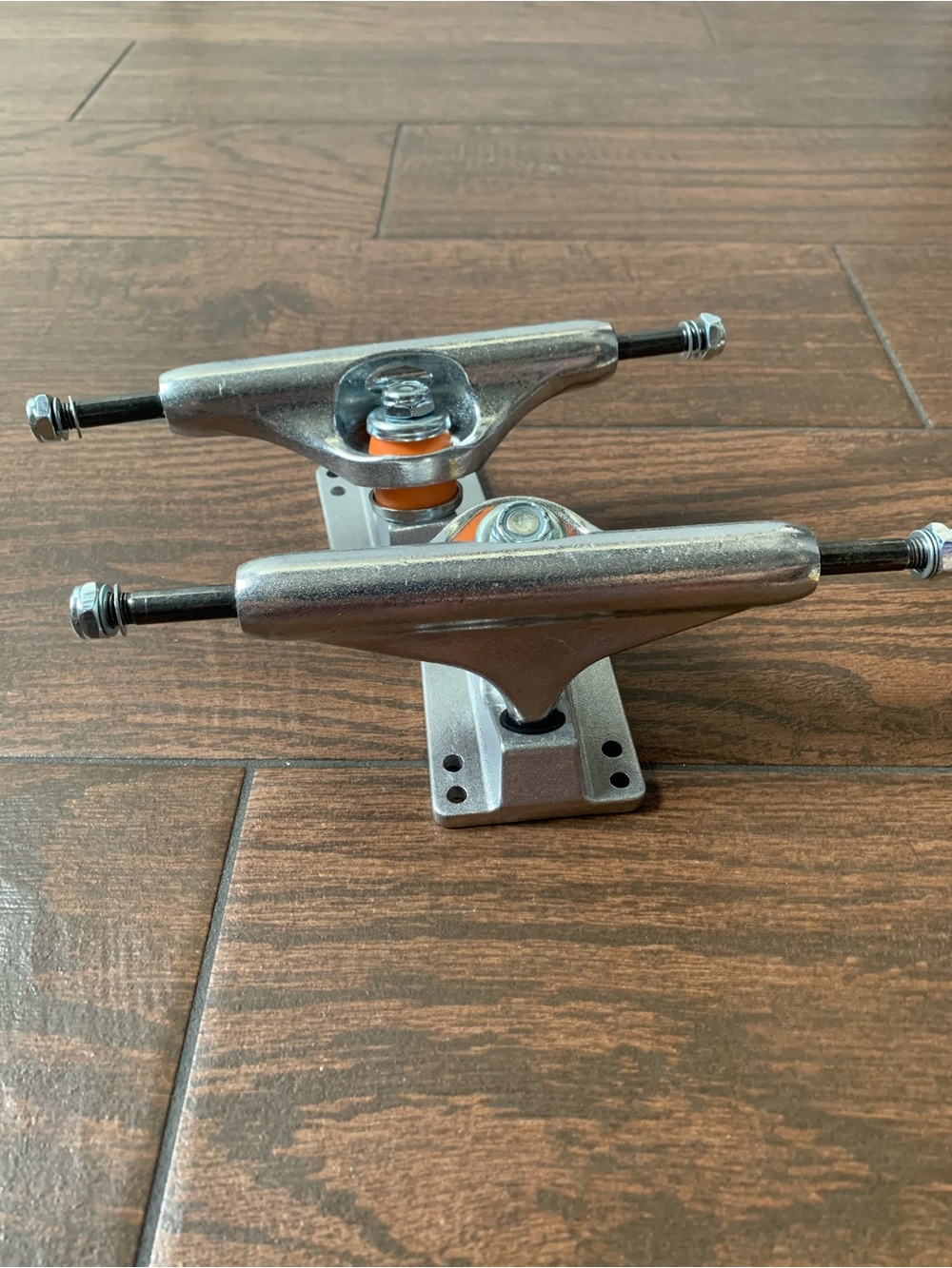 Silver Skateboard Trucks with Orange Bushings